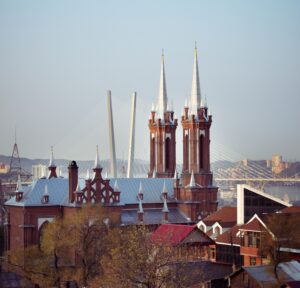 A view of Most Holy Mother of God Catholic Church in Vladivostok, showing the new roof and the steeples that were added to the building.  In the background is a section of one of the city's new cable-stayed bridges.
